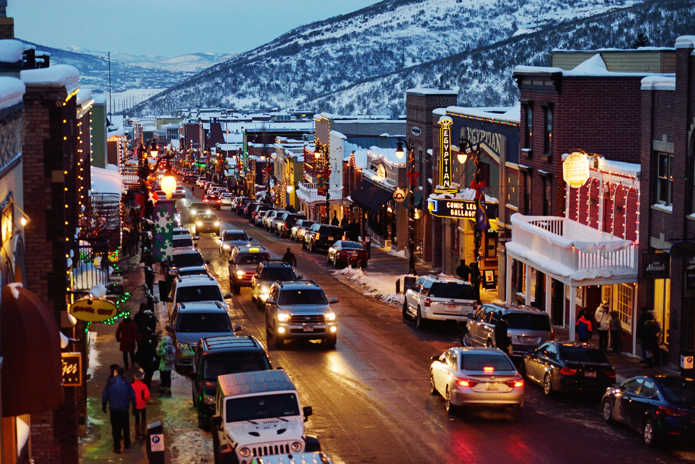 Main street in Park City in the winter with storefront decorated for the holidays. 