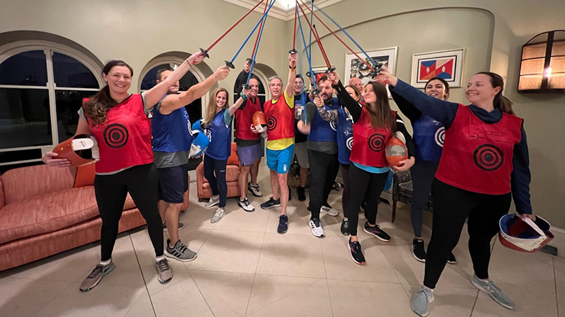 Inspirato members holding their fencing swords in the air all together.