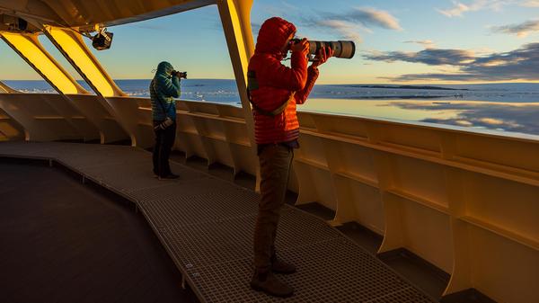 Inspirato members with camera's with long lenses held up to their faces taking pictures from the National Geographic Resolution