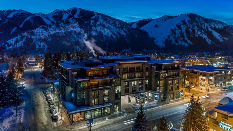 Limelight Hotel Ketchum exterior at night with Sun Valley resort mountain in the distance and the exterior of the hotel illuminated 