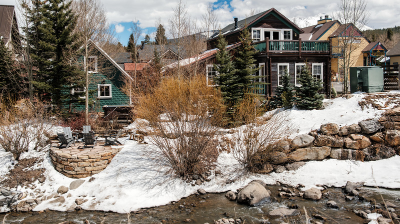 Exterior of the Fletcher in the winter with a river running along the house.