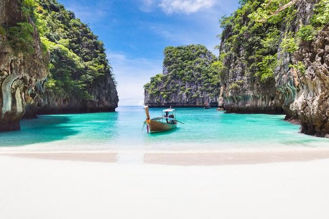 The Phi Phi islands beach with a traditional boat sitting in the water