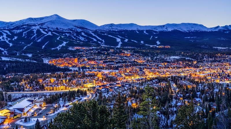 View of Breckenridge with the resort mountain in the distance at night with all the lights of the town illuminated.