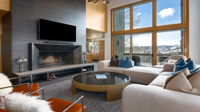 Sugar Ridge living room with large leather couch in front of a wall-mounted flat screen tv hanging above a fireplace.