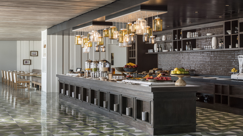 Indoor buffet area with modern overhead lights above all the food. 