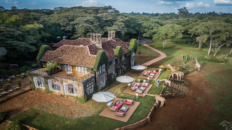 Aerial view of the Giraffe Manor with outside sitting areas and giraffe's grazing