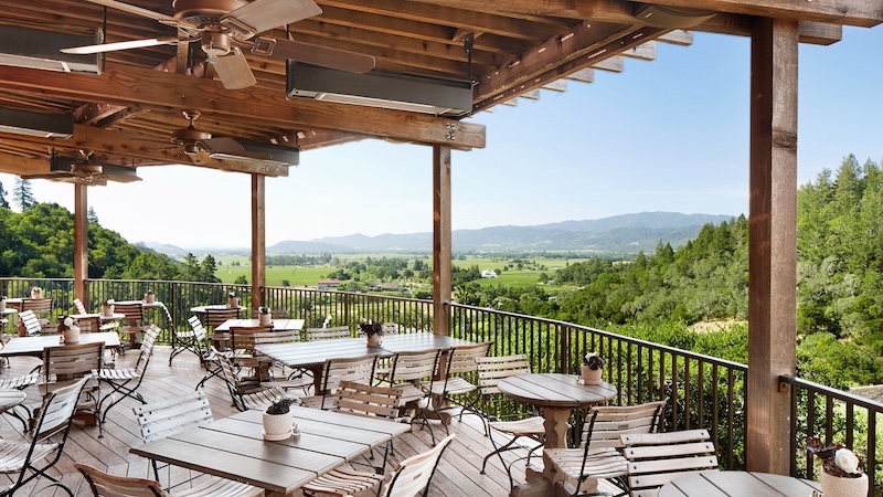 Auberge Du Solei outdoor dining area with views of nearby vineyards