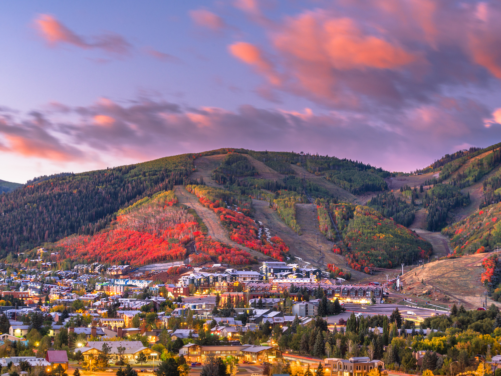 View of Park City with vibrant autumn colored trees on the mountain behind the town. 