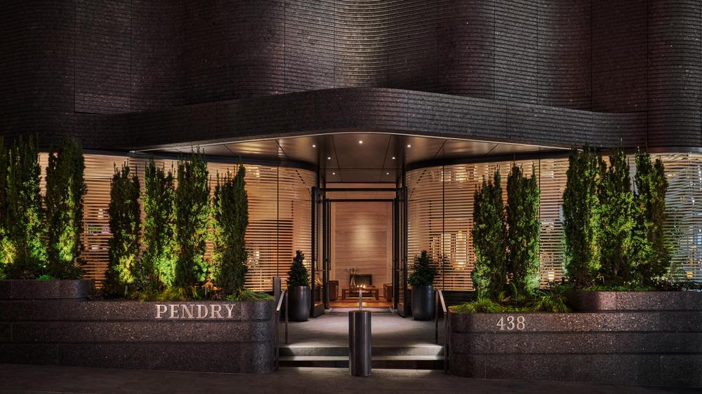 Entrance to Pendry Manhattan West with glass door and floor to ceiling windows and shrubbery to create some privacy. 