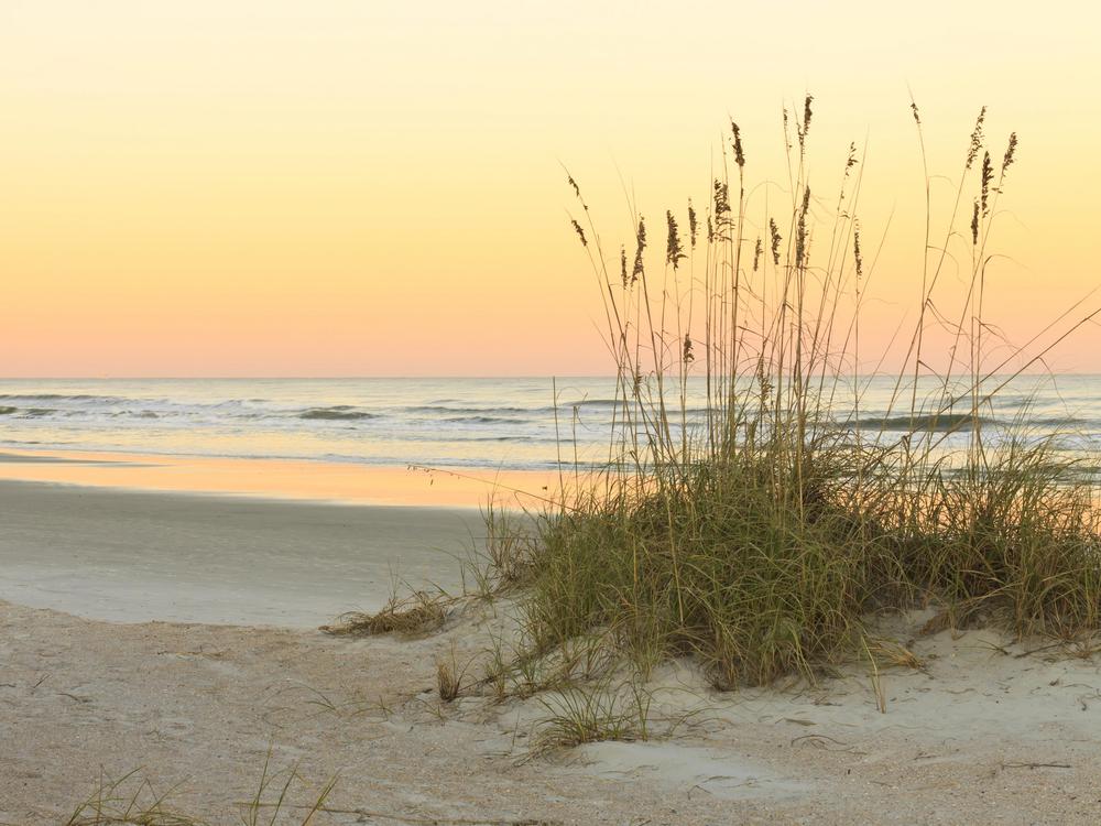 View of Rosemary Beach during sunset with pink and yellow on the ocean horizon. 